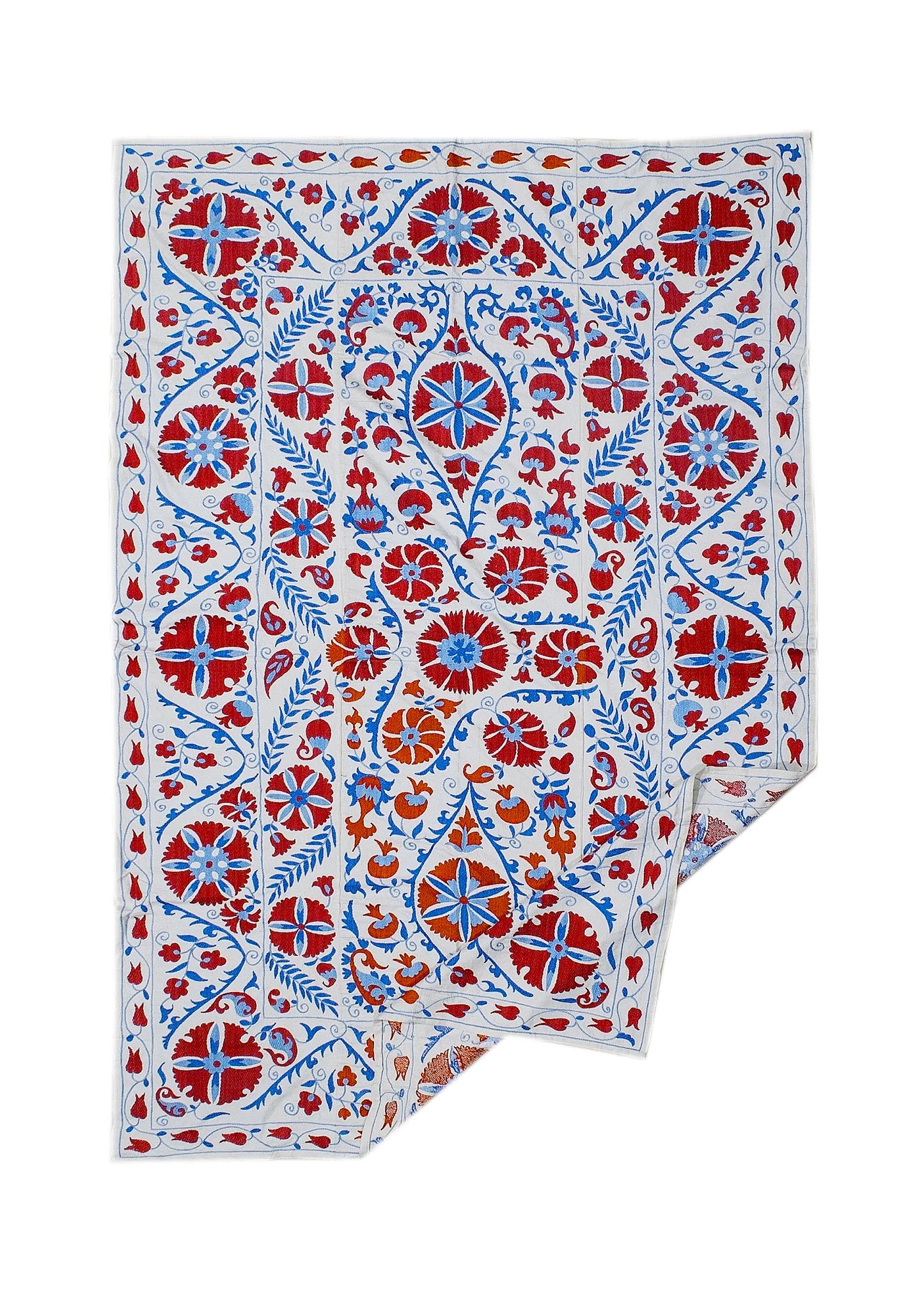 Hand-embroidered Uzbek Suzani textile featuring red and blue floral motifs on a white cotton base.
