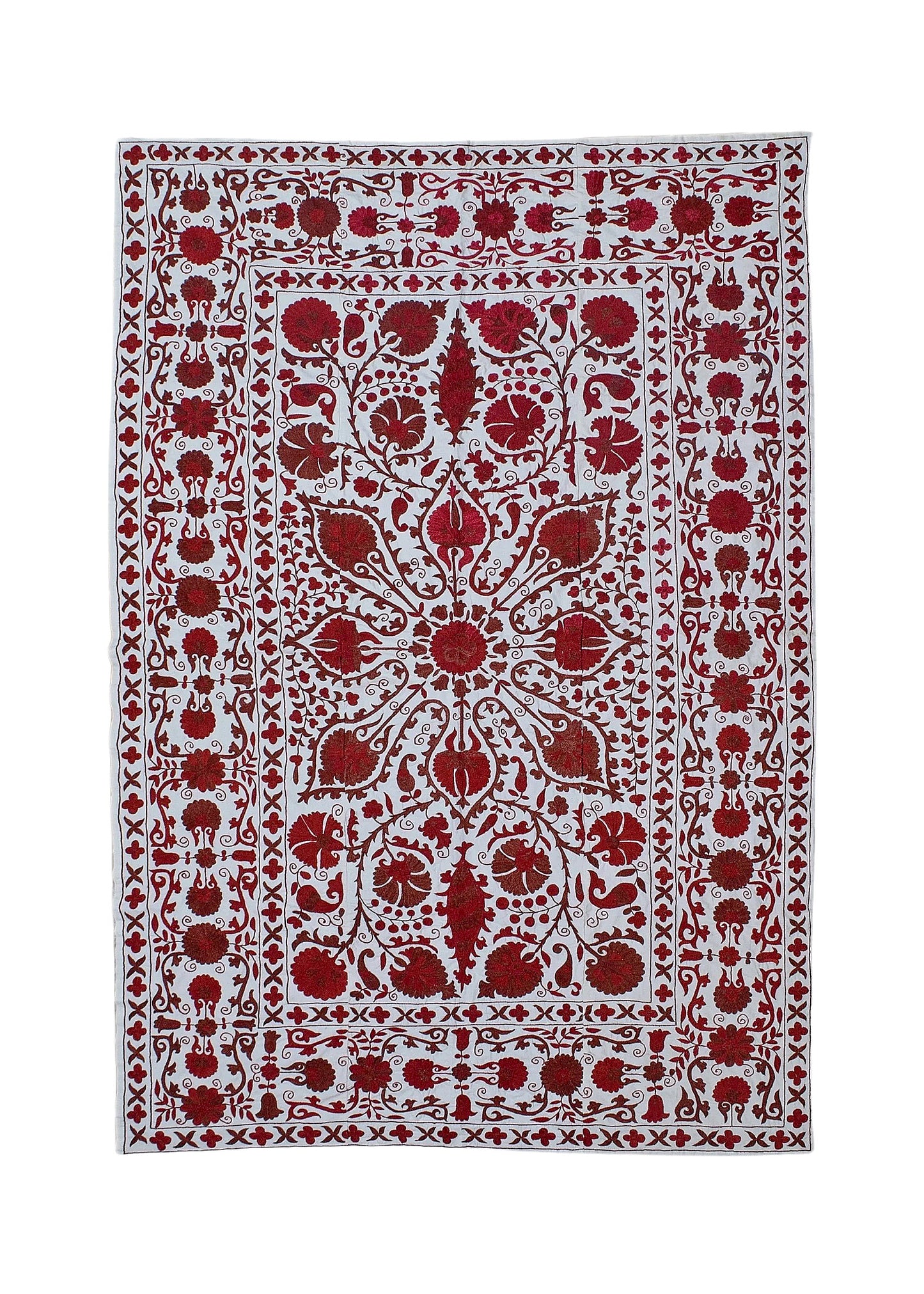 A rectangular Uzbek suzani featuring intricate red floral embroidery on a white cotton background.