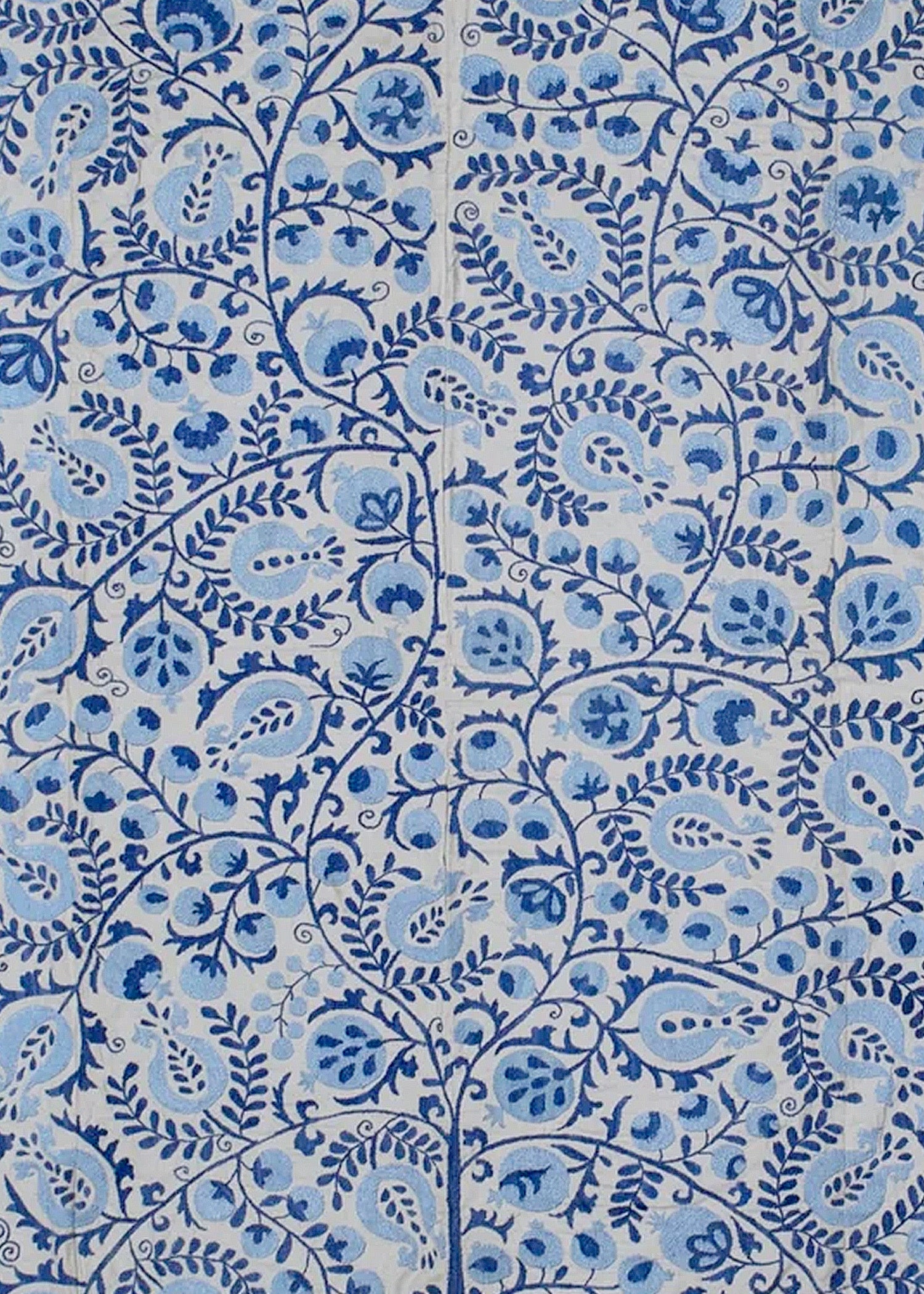 Hand-embroidered Uzbek Suzani textile featuring intricate blue floral and pomegranate motifs.