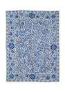 A rectangular Uzbek suzani featuring intricate blue floral and vine embroidery on a white base.