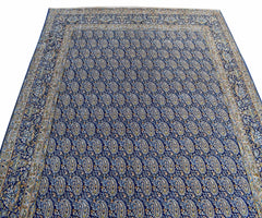 A vintage Persian Kerman rug featuring an all-over blue field with intricate paisley patterns.