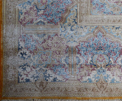A vintage Persian Kerman rug featuring an intricate floral medallion design in blue and red tones.