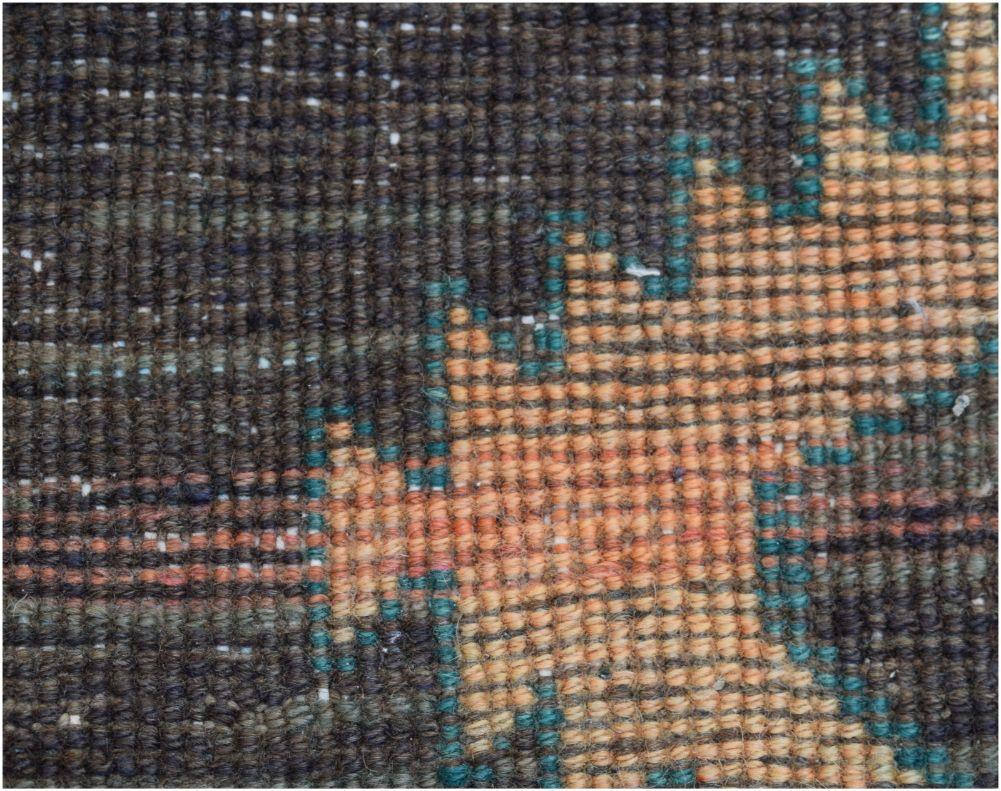 A close-up view of a handmade vintage Persian runner featuring a geometric pattern in wool.