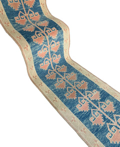A vintage Turkish Oushak runner featuring a blue field with pink tribal motifs and a cream border.