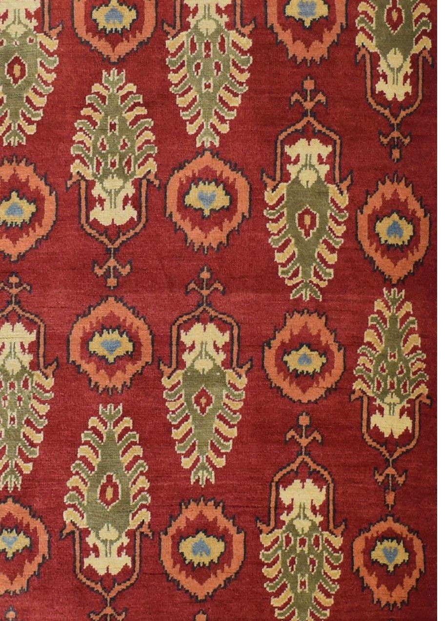 Handmade Afghan Chobi runner rug featuring a repeating pattern of green and orange floral motifs.