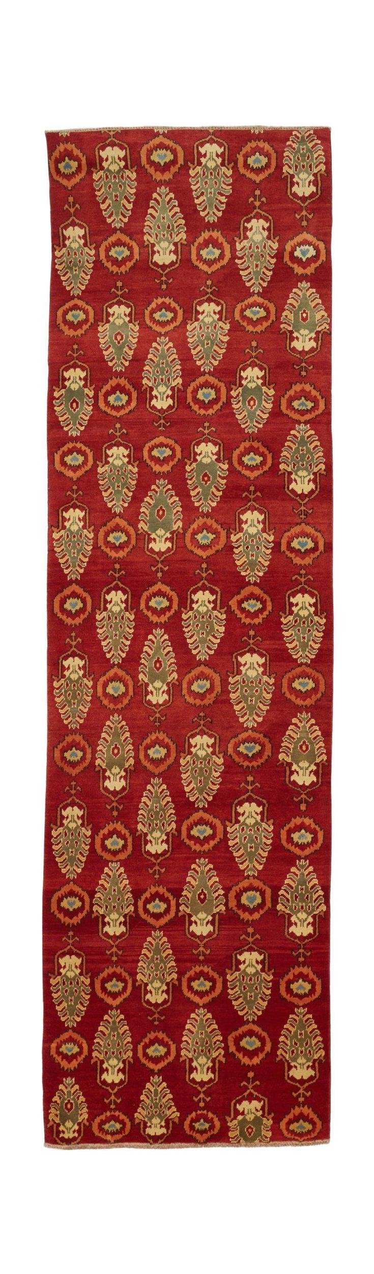 An Afghan Chobi runner rug featuring a red field with repeating green and orange floral motifs.