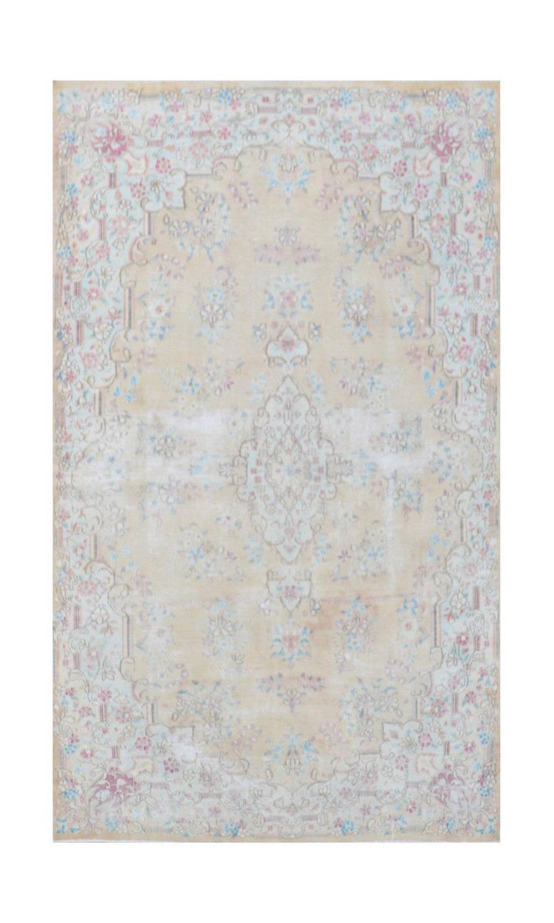 A vintage Persian Kerman rug featuring a central medallion and intricate floral patterns in soft hues.