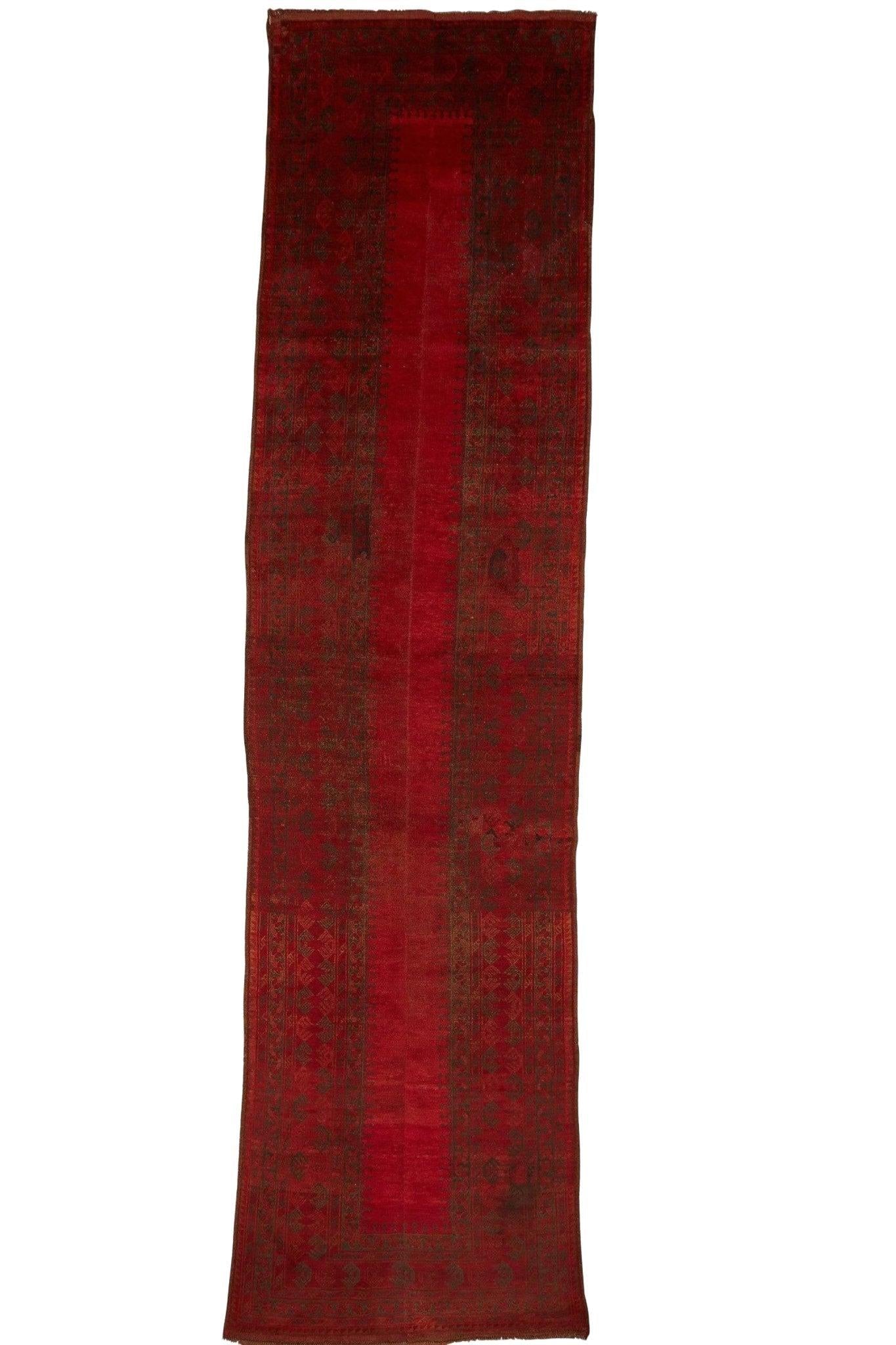 A vintage handmade Afghan Turkmen wool runner featuring a deep red field with a central seam.