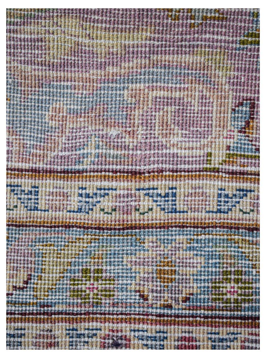 A close-up of a vintage Persian Kerman runner featuring intricate floral patterns in soft colors.
