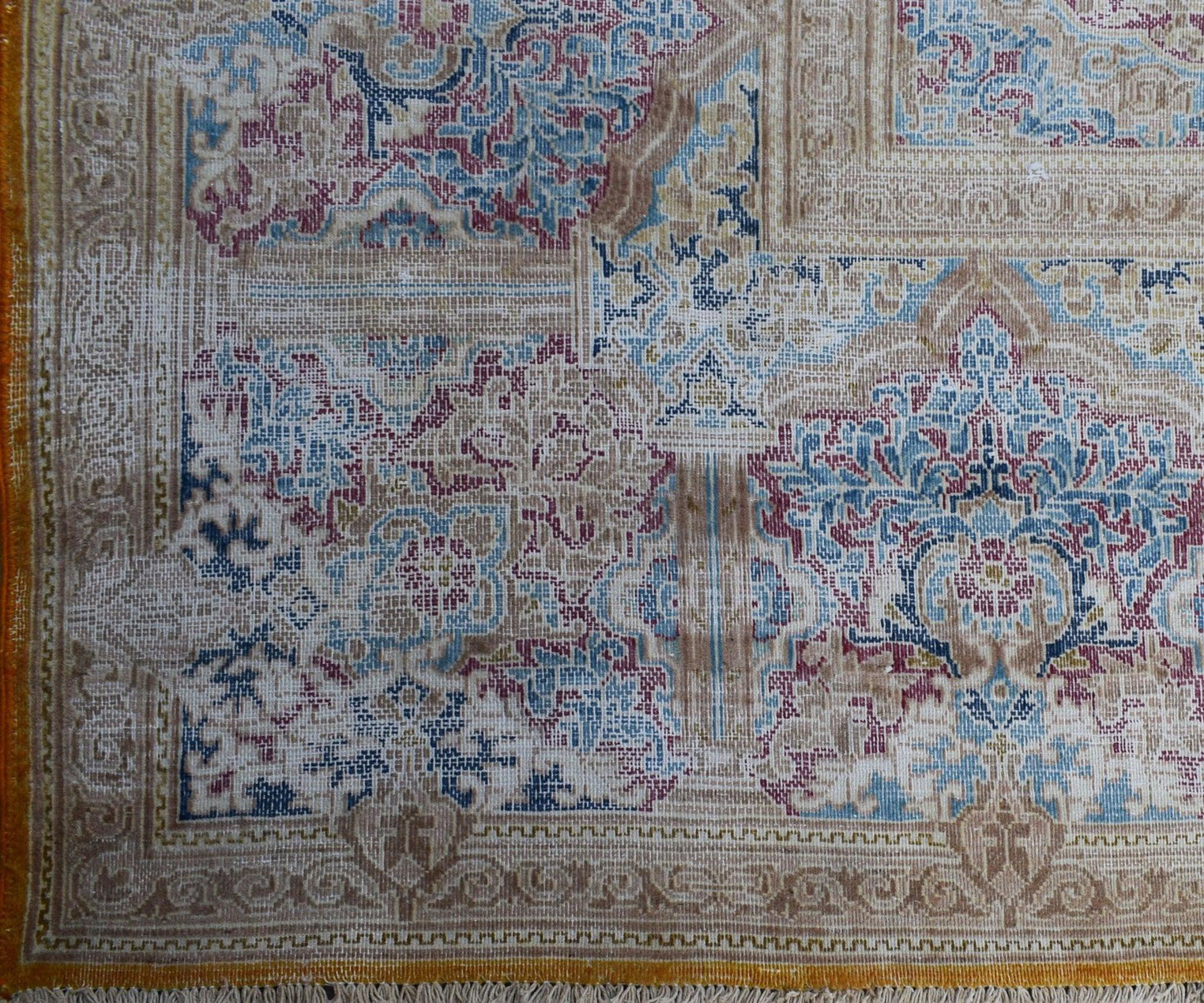 A vintage Persian Kerman rug featuring an intricate floral medallion design in blue and red tones.