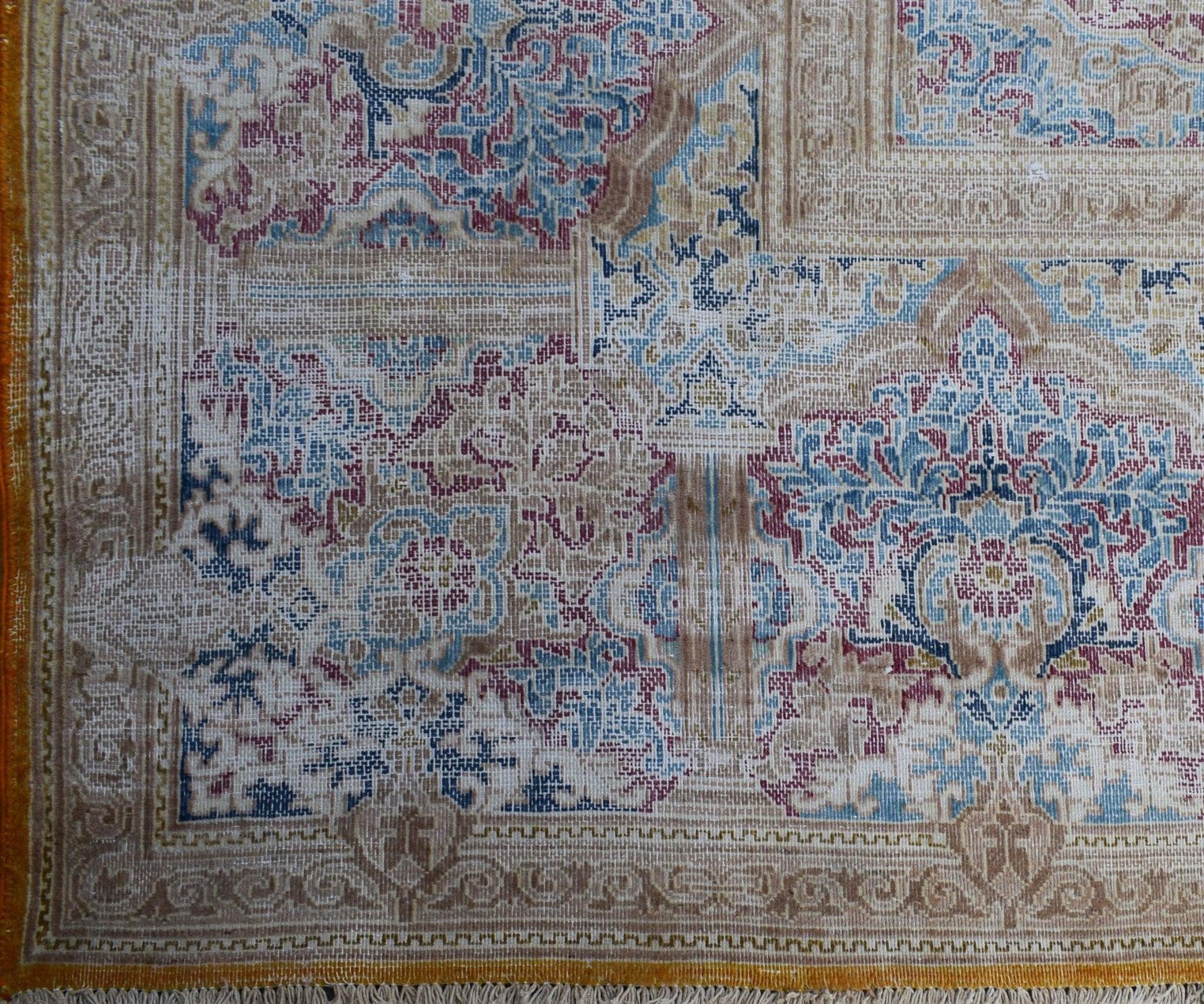 A vintage Persian Kerman rug featuring an intricate floral medallion design in blue and red tones.