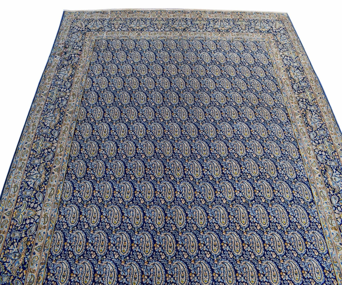A vintage Persian Kerman rug featuring an all-over blue field with intricate paisley patterns.