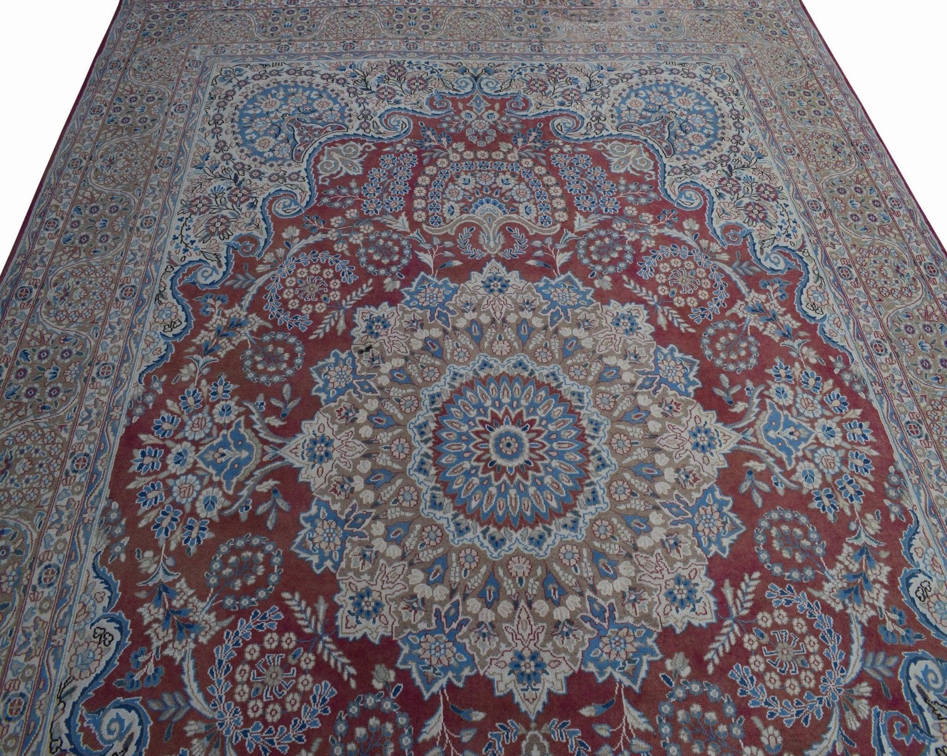 A vintage Persian Kerman rug featuring a central medallion and intricate floral patterns.