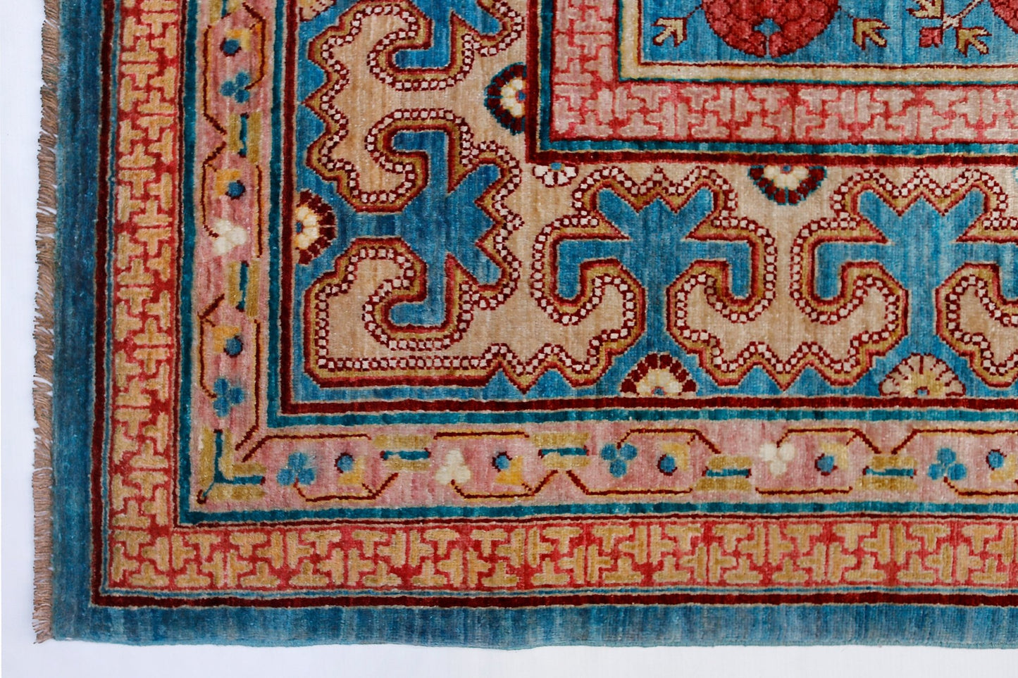 A handwoven Afghan Balkh rug featuring a traditional Khotan pattern in blue, red, and beige tones.