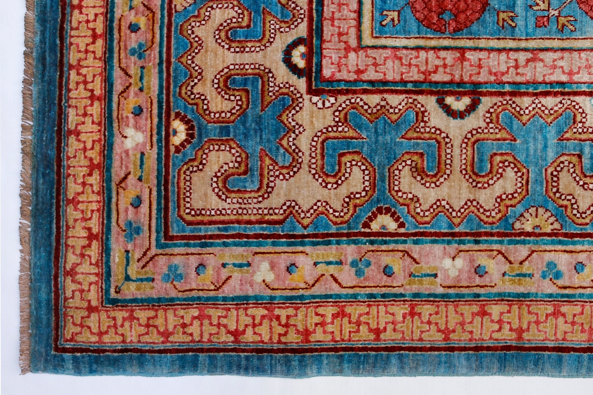 A handwoven Afghan Balkh rug featuring a traditional Khotan pattern in blue, red, and beige tones.