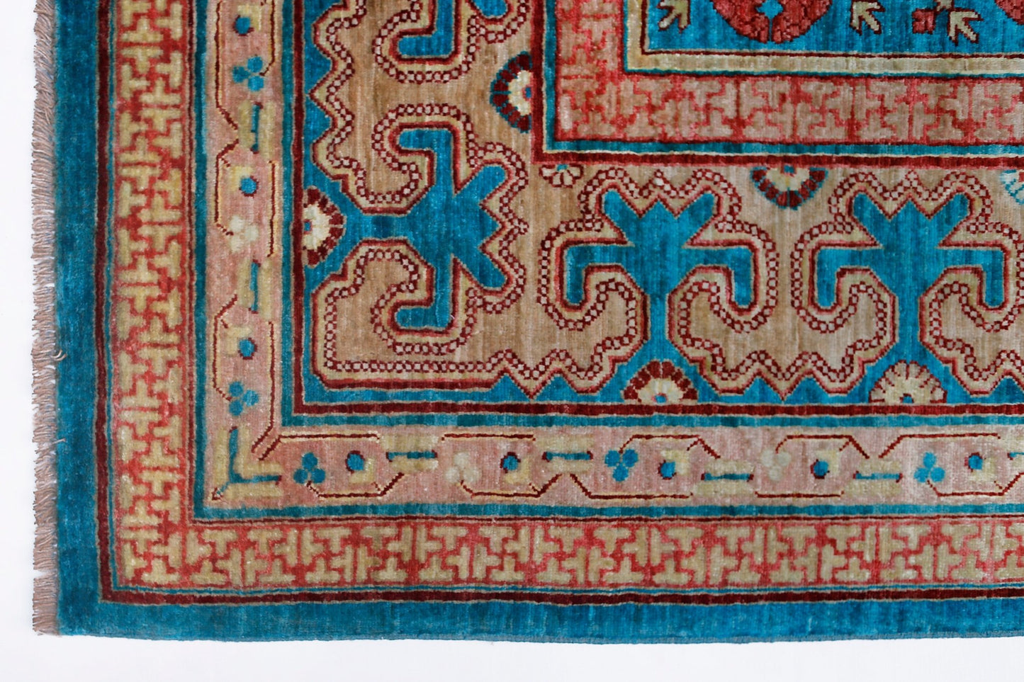 A handwoven Afghan Balkh rug featuring a geometric Khotan pattern in blue, red, and tan tones.