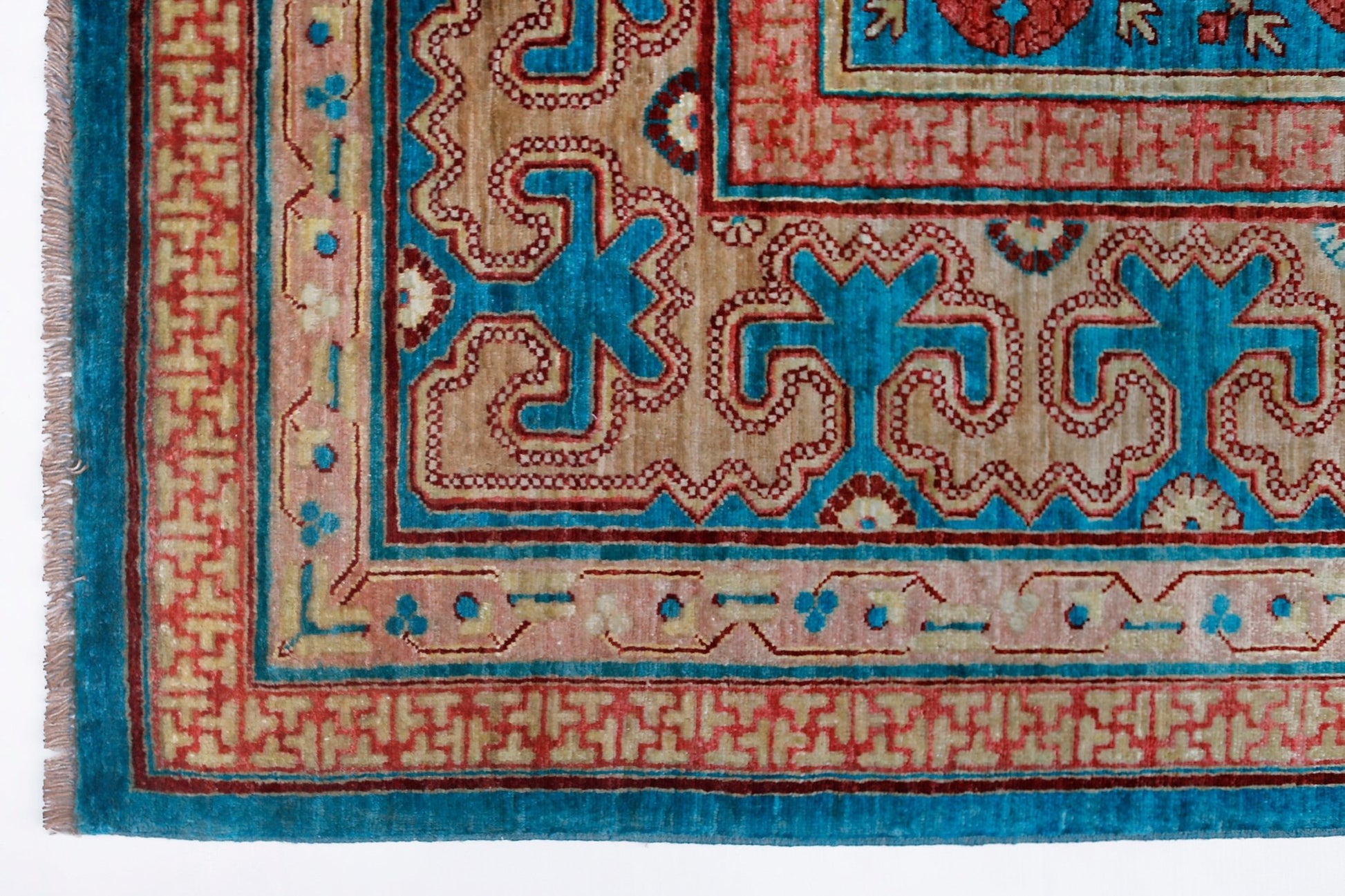 A handwoven Afghan Balkh rug featuring a geometric Khotan pattern in blue, red, and tan tones.