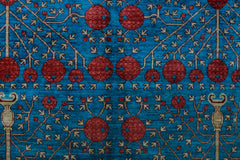 A handwoven Afghan Balkh rug featuring a repeating pattern of red pomegranate motifs on a blue field.