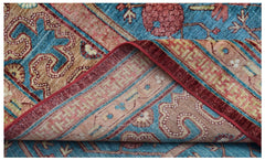 A folded Afghan Balkh rug featuring intricate traditional patterns in blue, red, and tan tones.