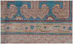 A close-up of an Afghan Balkh rug featuring geometric patterns in blue, red, and beige tones.