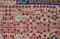 A close-up of a handmade Afghan Balkh rug featuring intricate red and blue geometric patterns.