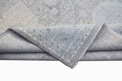 A handwoven Afghan Balkh rug in a light blue Mamluk pattern with a folded corner.