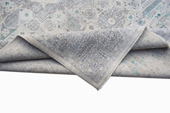 A handwoven Afghan Balkh rug with a grey and blue Mamluk pattern folded to show its texture.