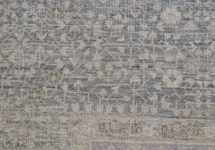 A close-up of a handwoven Afghan rug featuring a detailed blue and cream Mamluk pattern.
