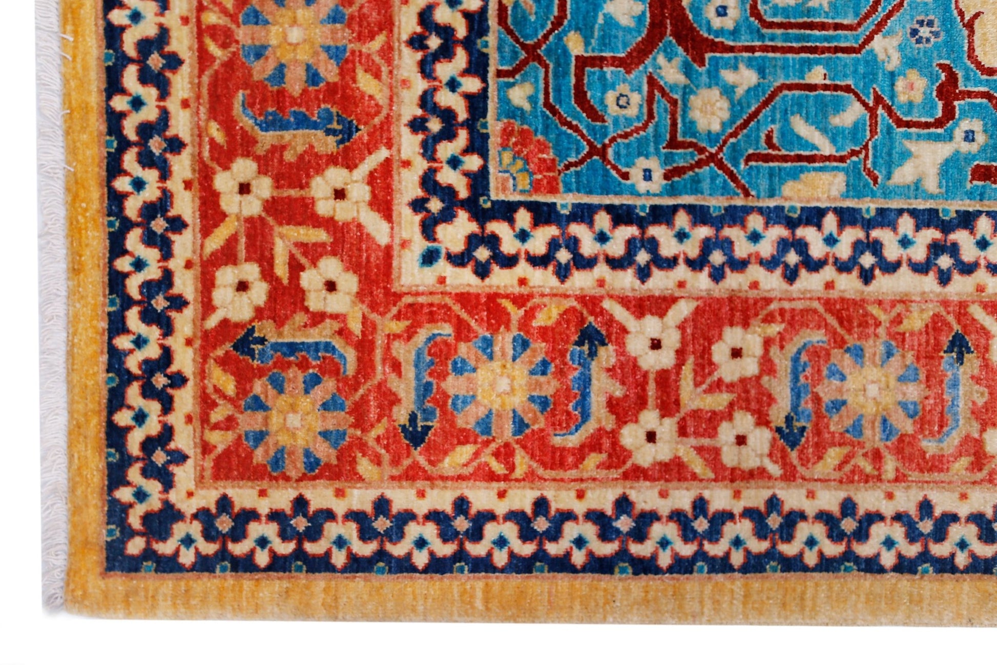 A corner view of a handwoven Afghan Balkh rug featuring intricate floral patterns in red, blue, and cream.