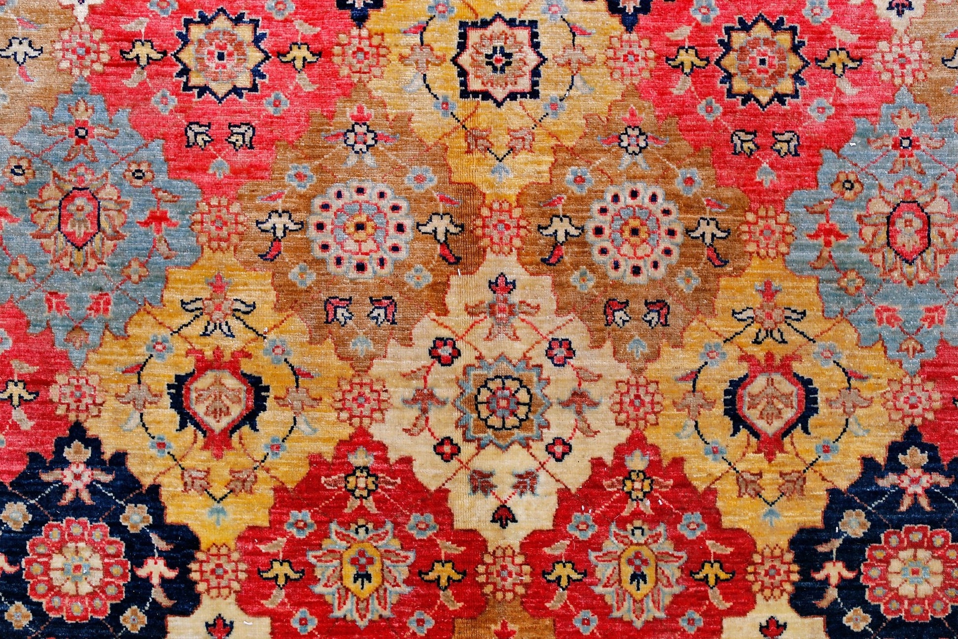 Handwoven Afghan Balkh rug featuring a geometric floral pattern in red, gold, and blue tones.