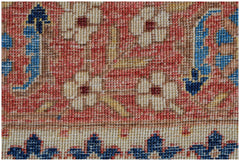 A close-up of a handmade Afghan Balkh rug featuring floral patterns in red, blue, and cream.