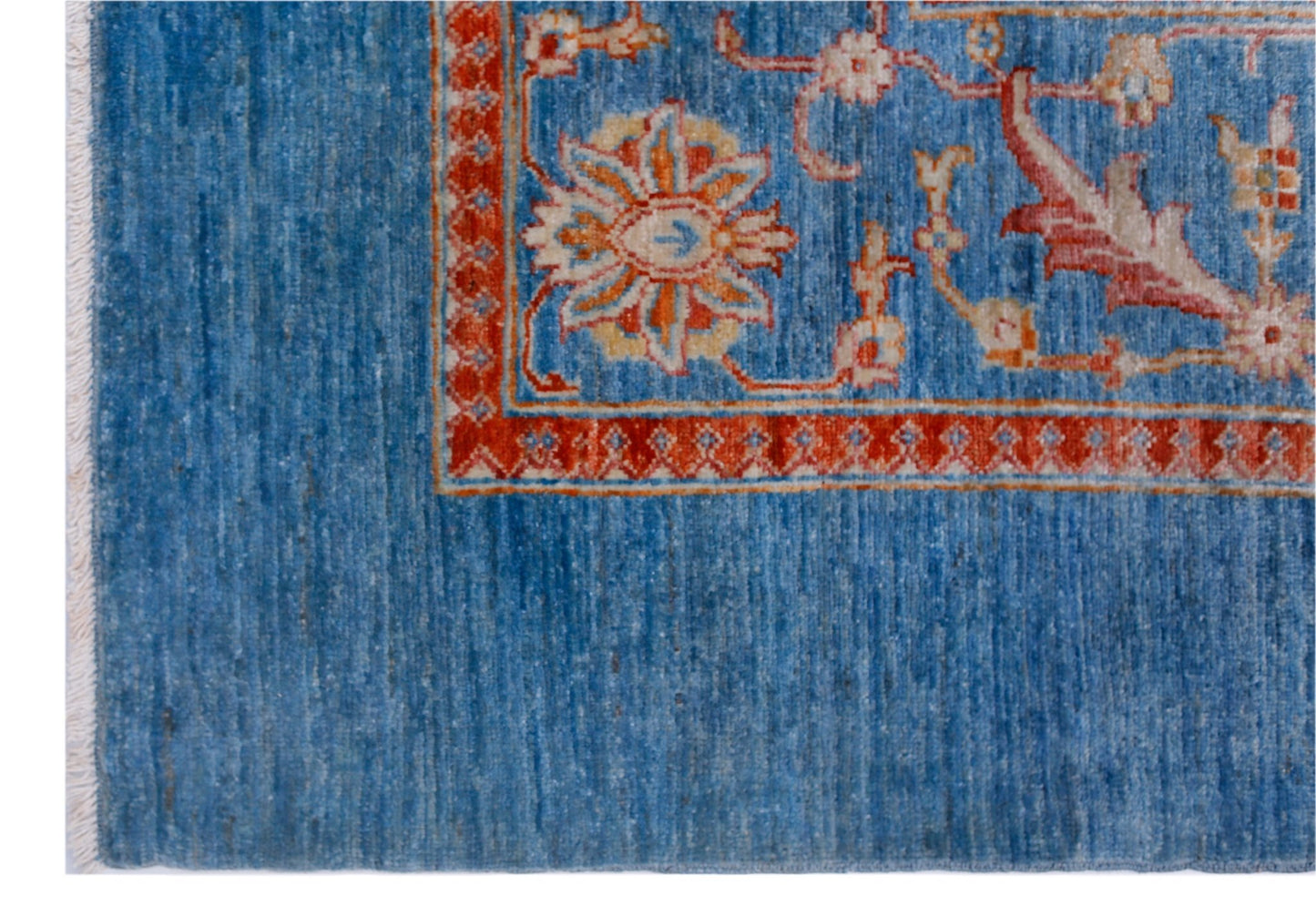 A handwoven Afghan Balkh rug featuring a blue field with a floral border in red and cream.