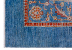 A handwoven Afghan Balkh rug featuring a blue field with a floral border in red and cream.