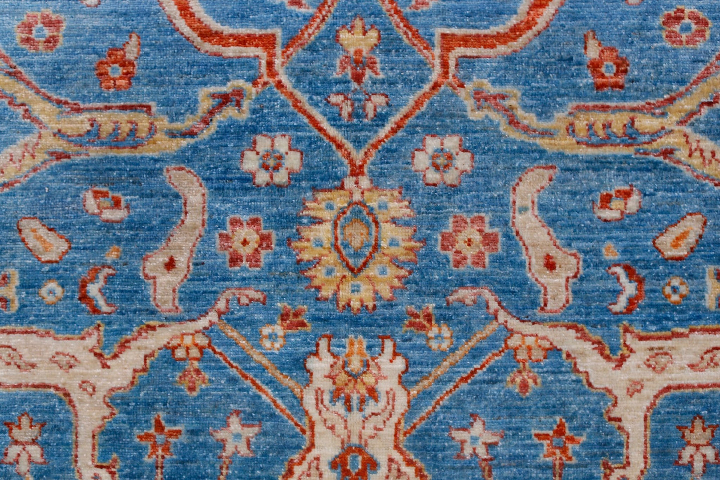 Handwoven Afghan Balkh rug featuring a traditional floral pattern in blue, red, and cream tones.