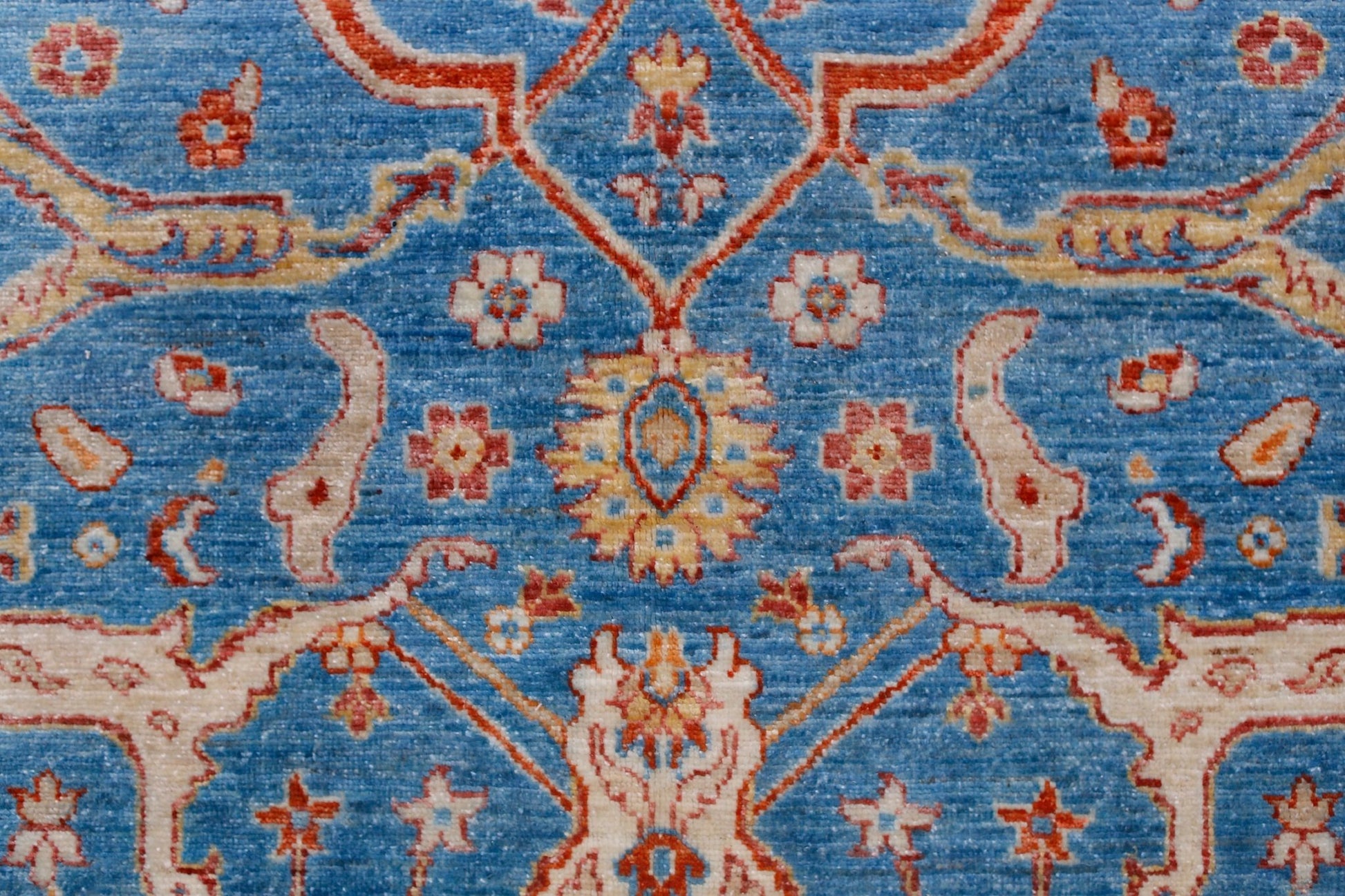 Handwoven Afghan Balkh rug featuring a traditional floral pattern in blue, red, and cream tones.