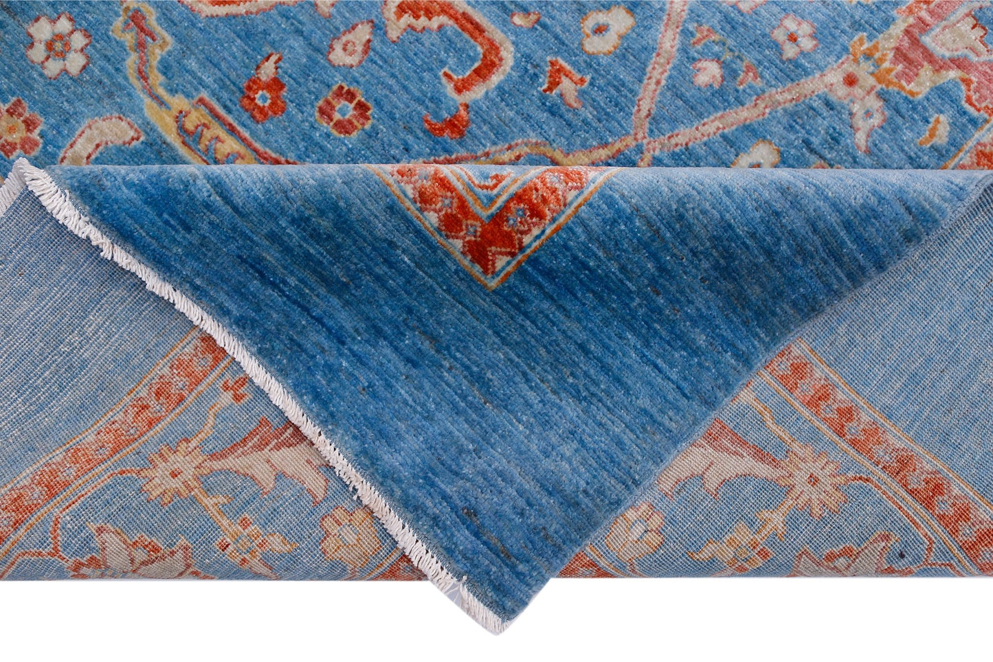 A handwoven Afghan Balkh rug featuring a blue field with intricate orange and cream floral patterns.