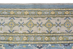 An Afghan Balkh rug featuring a floral border pattern in shades of blue, yellow, and beige.
