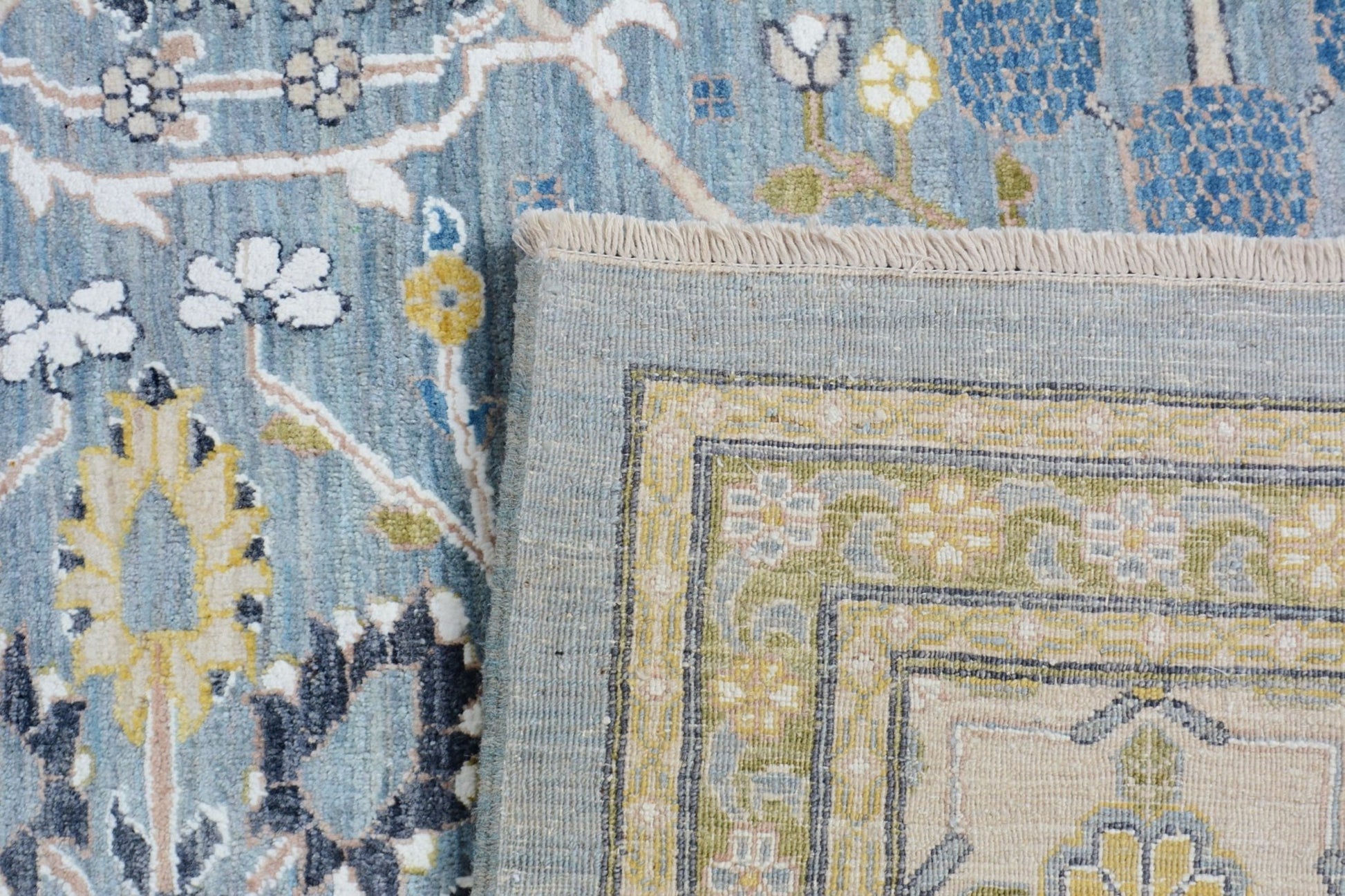 A handmade Afghan Balkh rug featuring a blue floral pattern and a detailed border.