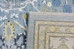 A handmade Afghan Balkh rug featuring a blue floral pattern and a detailed border.