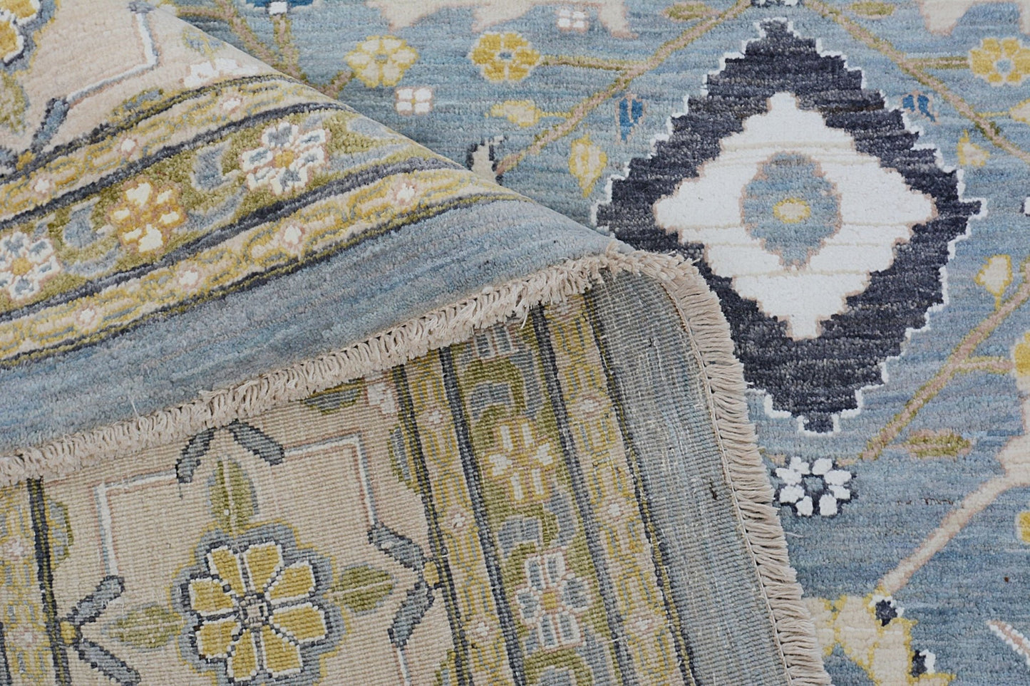 A handmade Afghan Balkh rug featuring a blue field with floral motifs and a dark central medallion.