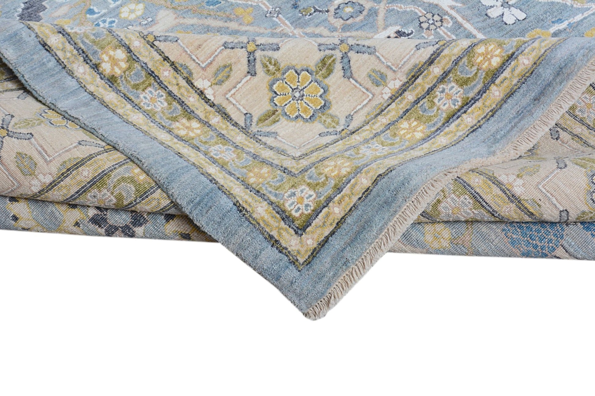 A folded Afghan Balkh rug featuring a traditional floral pattern in blue, beige, and green tones.