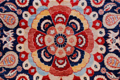A handwoven Afghan Balkh rug featuring a detailed floral medallion in red, blue, and cream tones.