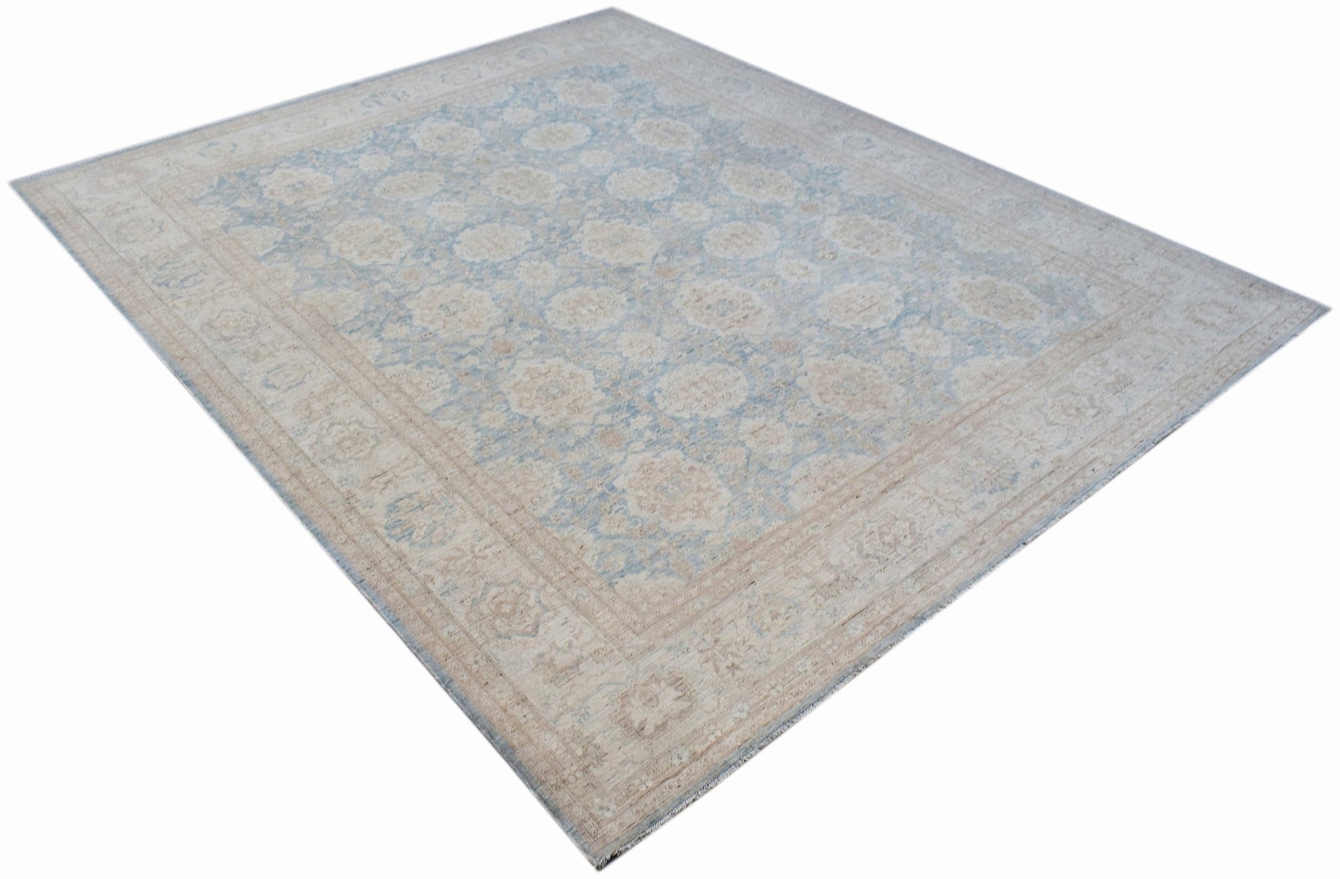 An Afghan Balkh rug featuring a traditional floral pattern in soft blue and beige tones.