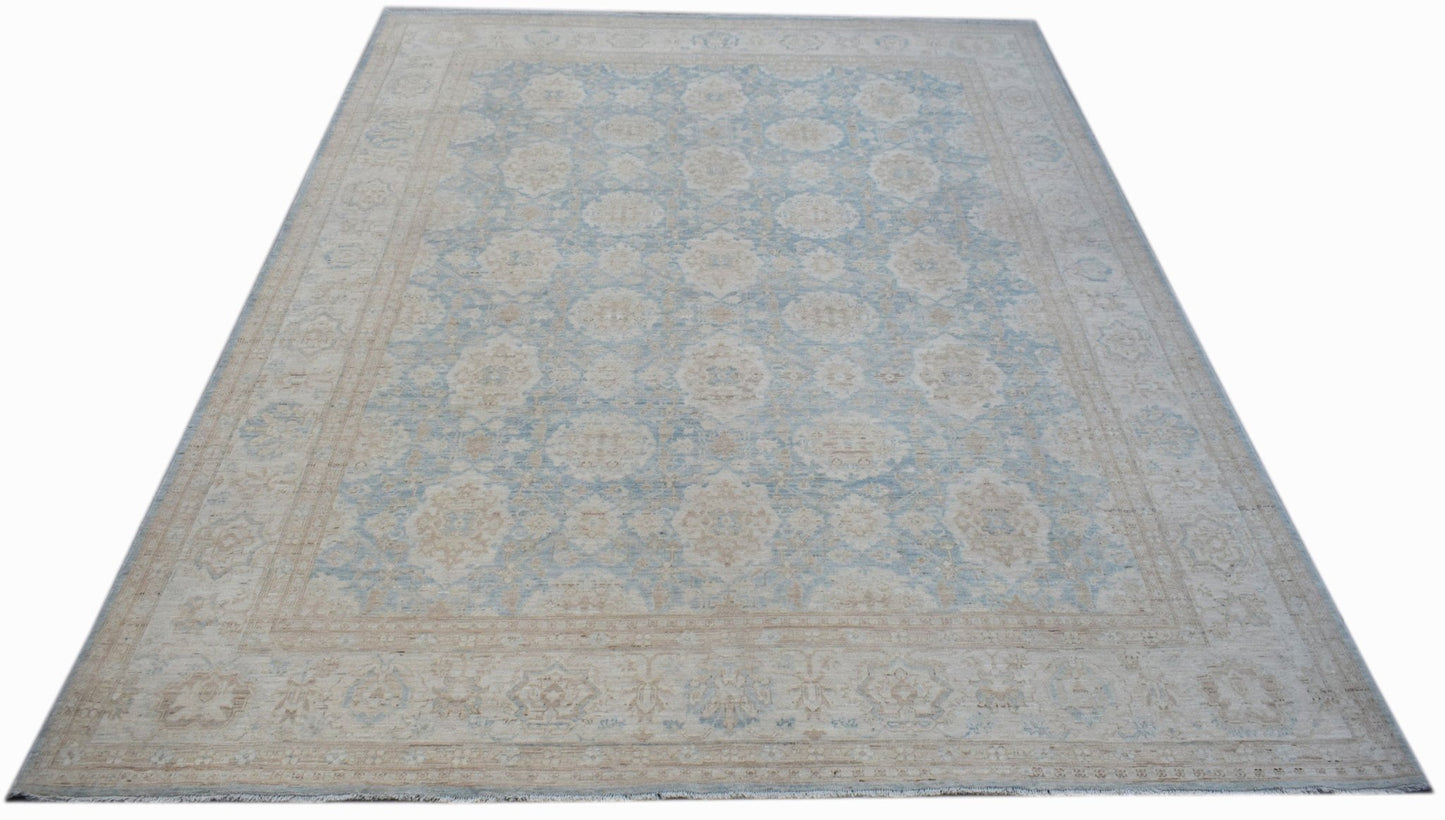 A handmade Afghan Balkh rug featuring a traditional floral pattern in soft blue and beige tones.