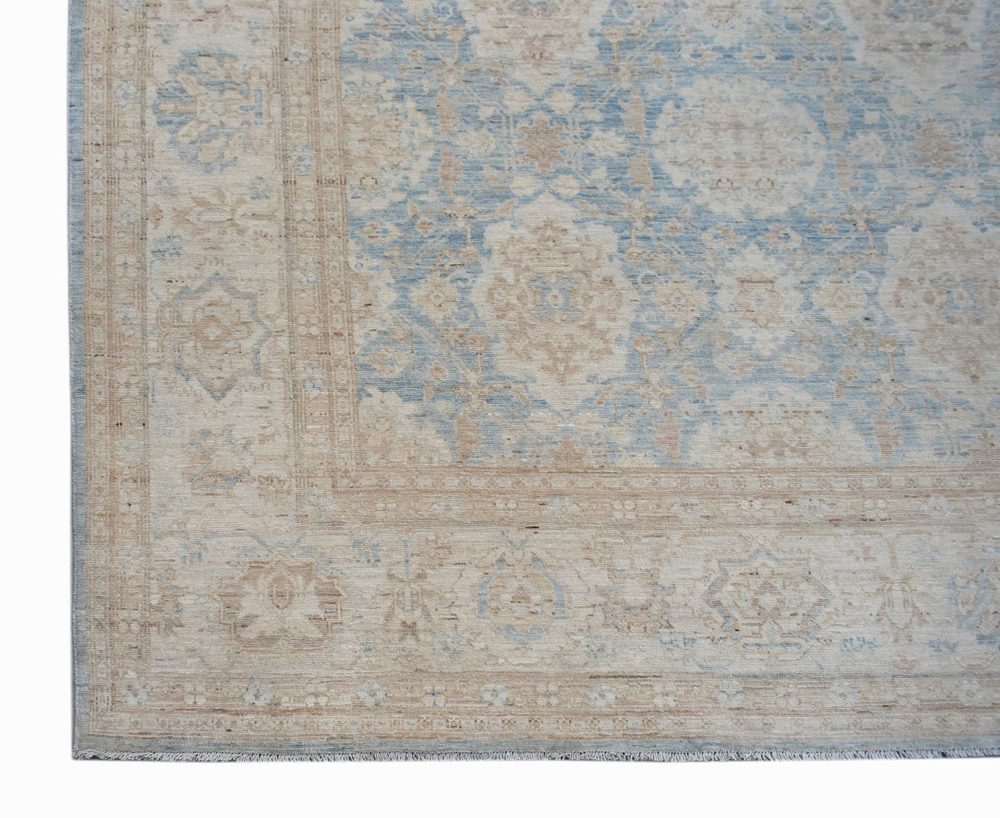 A handmade Afghan Balkh rug featuring a traditional floral pattern in soft blue and beige tones.