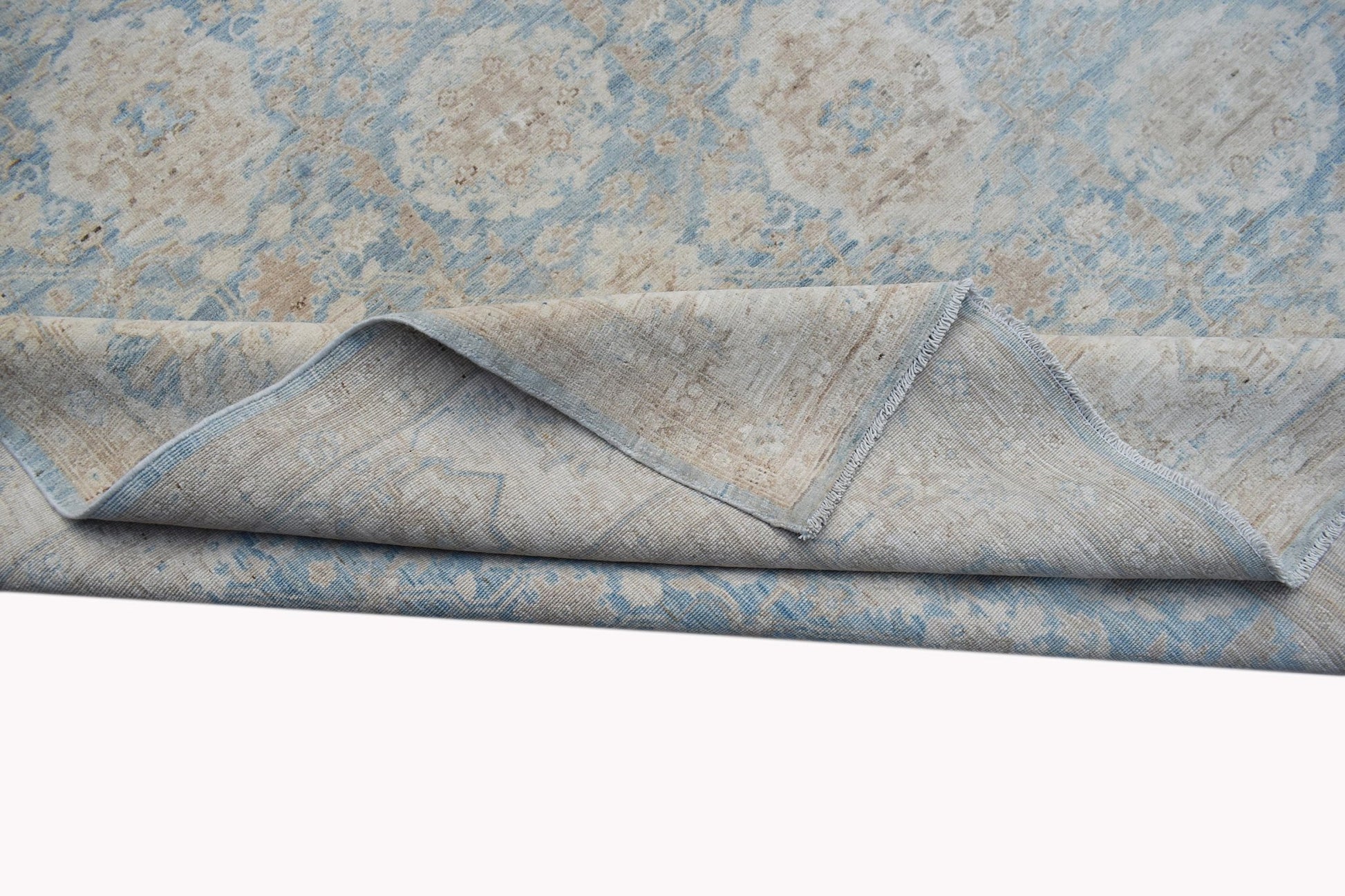 A handmade Afghan Balkh rug featuring a traditional floral pattern in soft blue and beige tones.