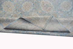 A handmade Afghan Balkh rug featuring a traditional floral pattern in soft blue and beige tones.