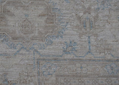 A close-up view of a handwoven Afghan Balkh rug featuring a neutral beige pattern with blue accents.