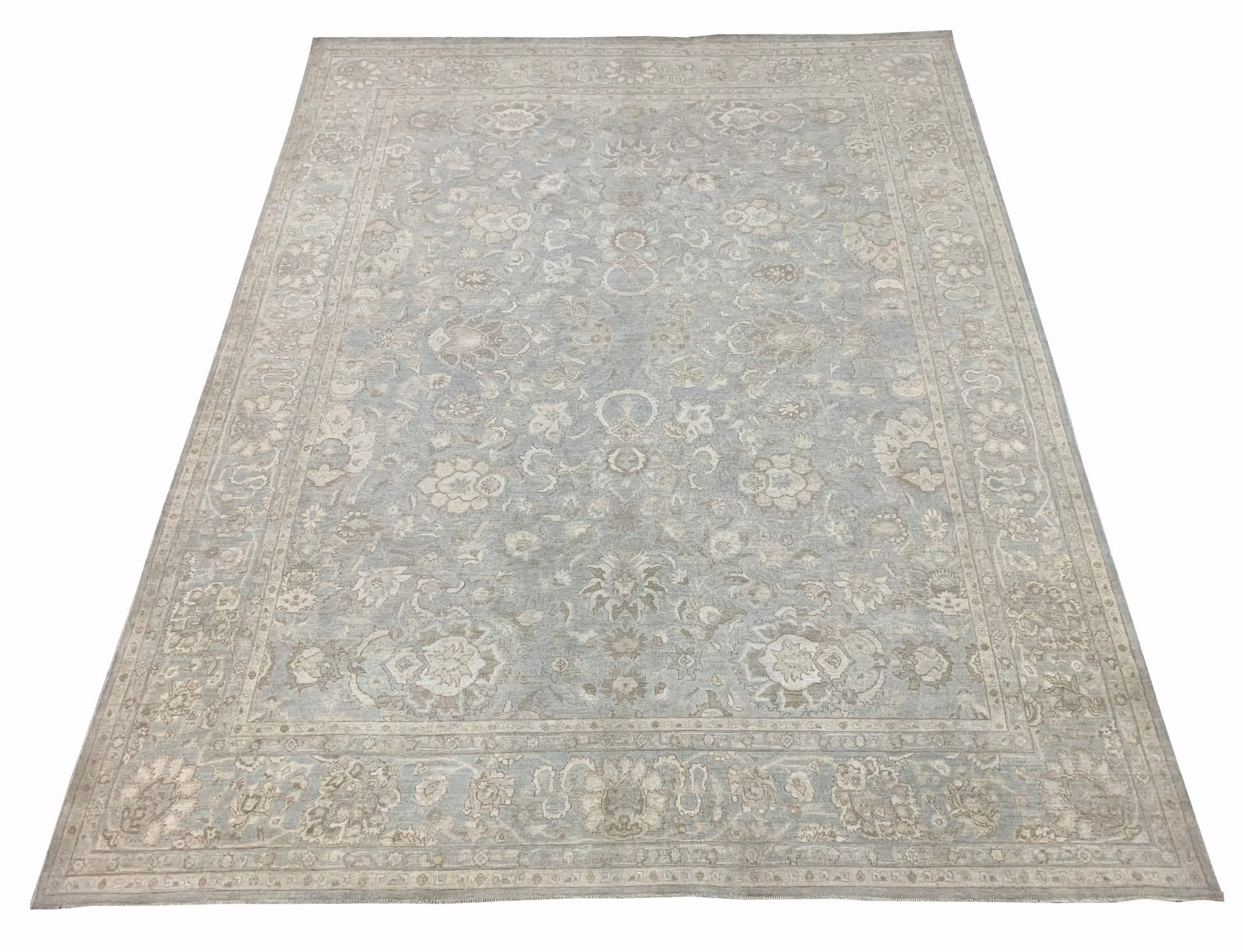 A handmade Afghan Balkh rug featuring a traditional floral pattern in soft blue and beige tones.