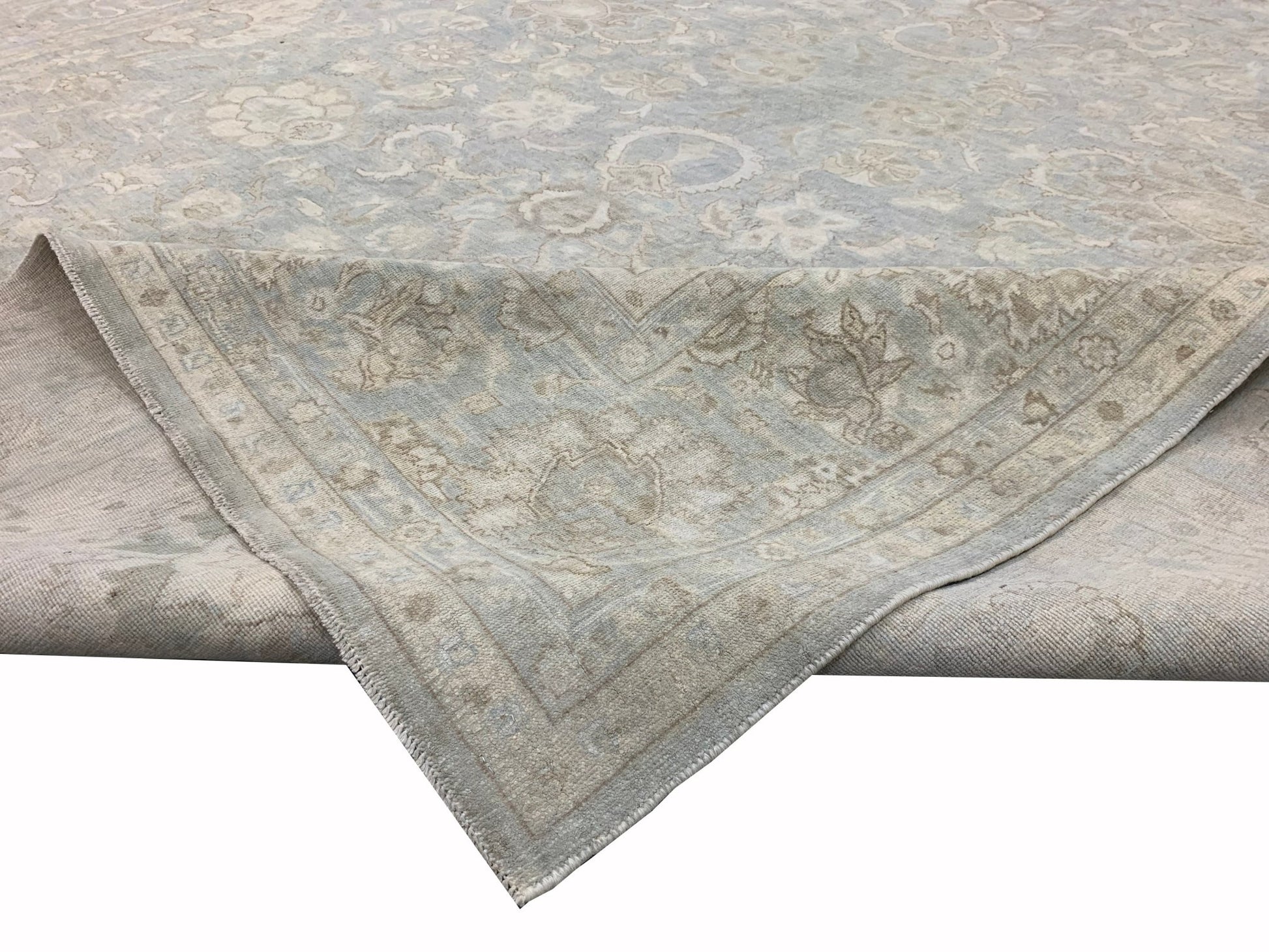 A handmade Afghan Balkh rug featuring a traditional floral pattern in soft blue and beige tones.